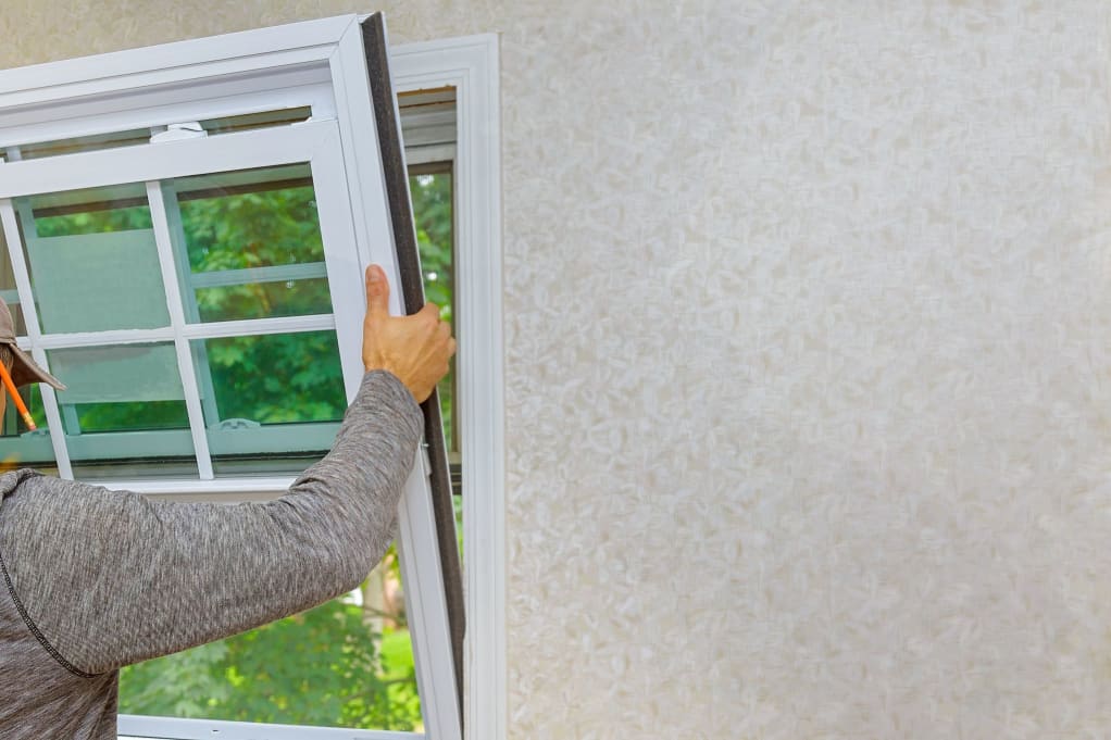 A person installing an energy efficient window